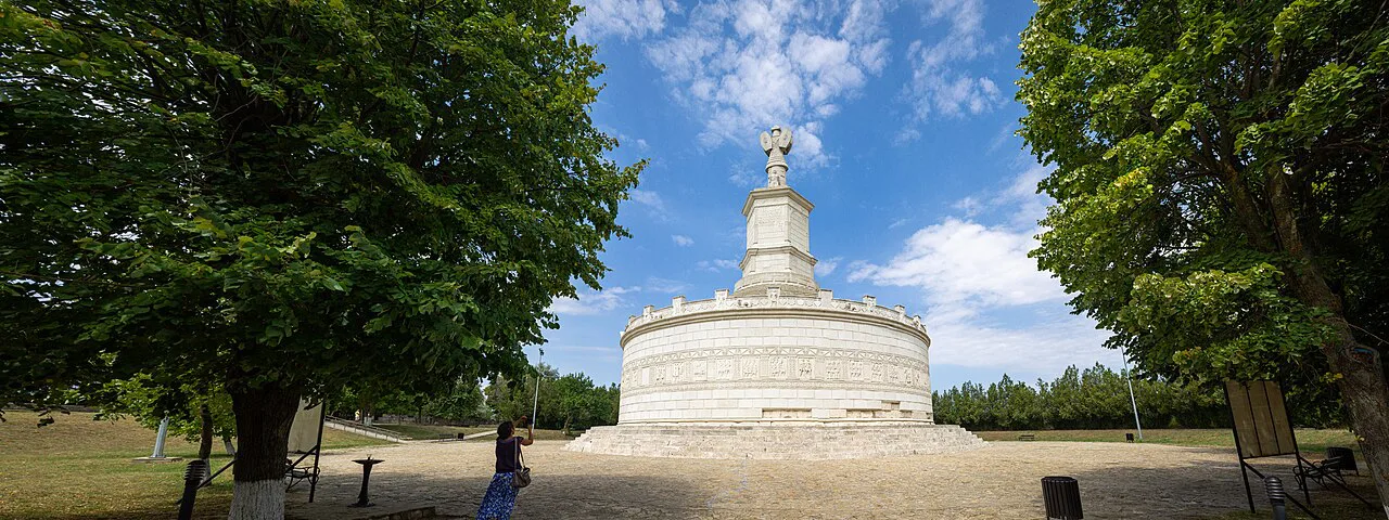 Tropaeum Traiani at Adamclisi framed by trees.