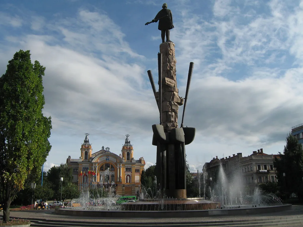 Piața Avram Iancu with the Avram Iancu statue and the National Theatre in Cluj-Napoca.