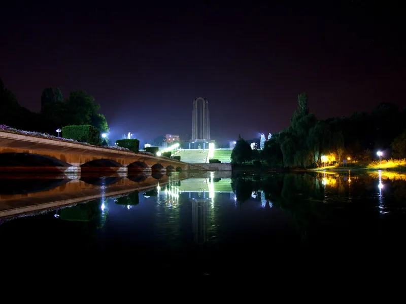 The Heroes' Monument in Carol Park, Bucharest, lit at night.