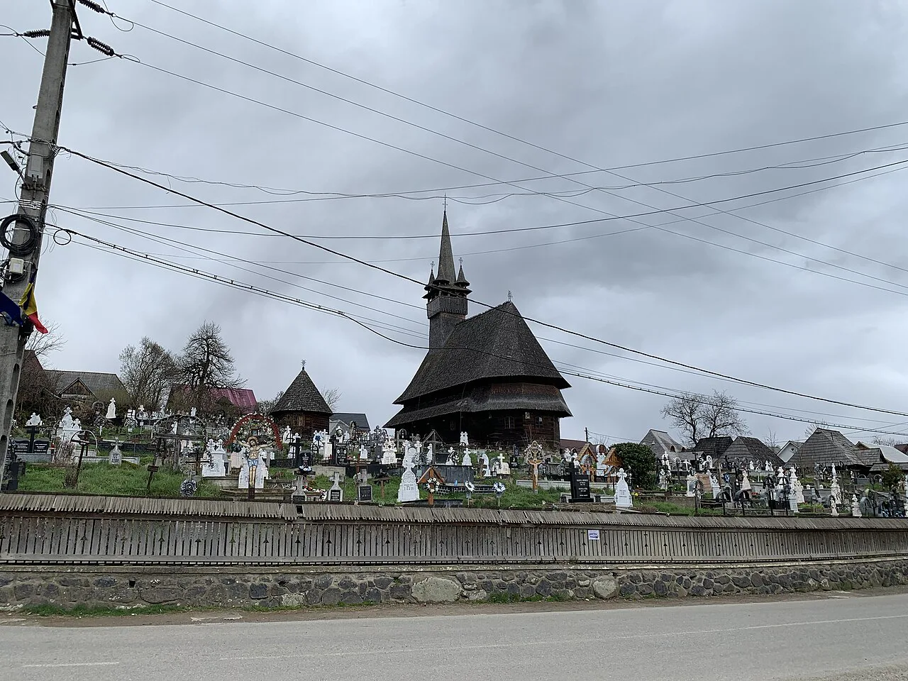 The Saint Nicholas wooden church in Budești Josani above its cemetery.