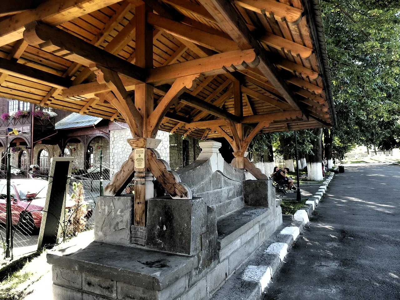 A carved wooden well shelter in Bușteni.