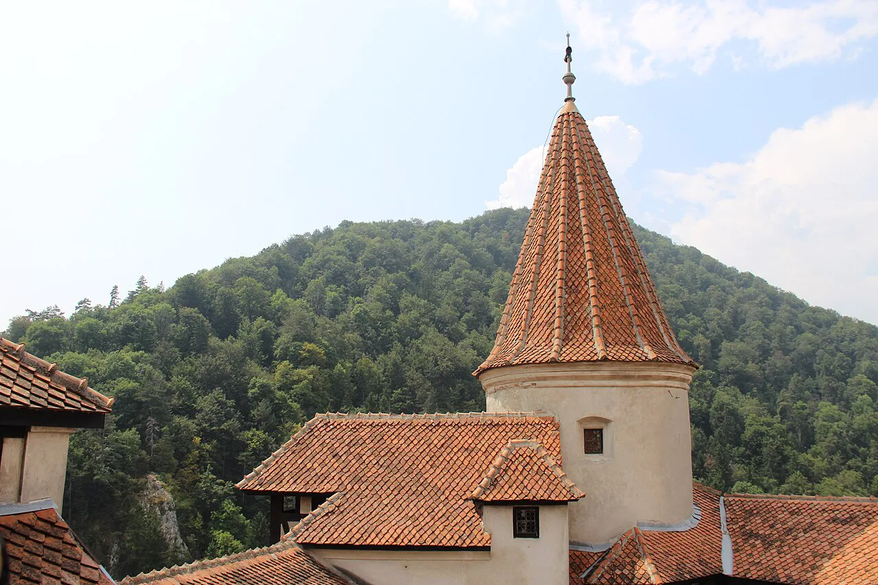 Tower of Bran Castle above the forested hills.