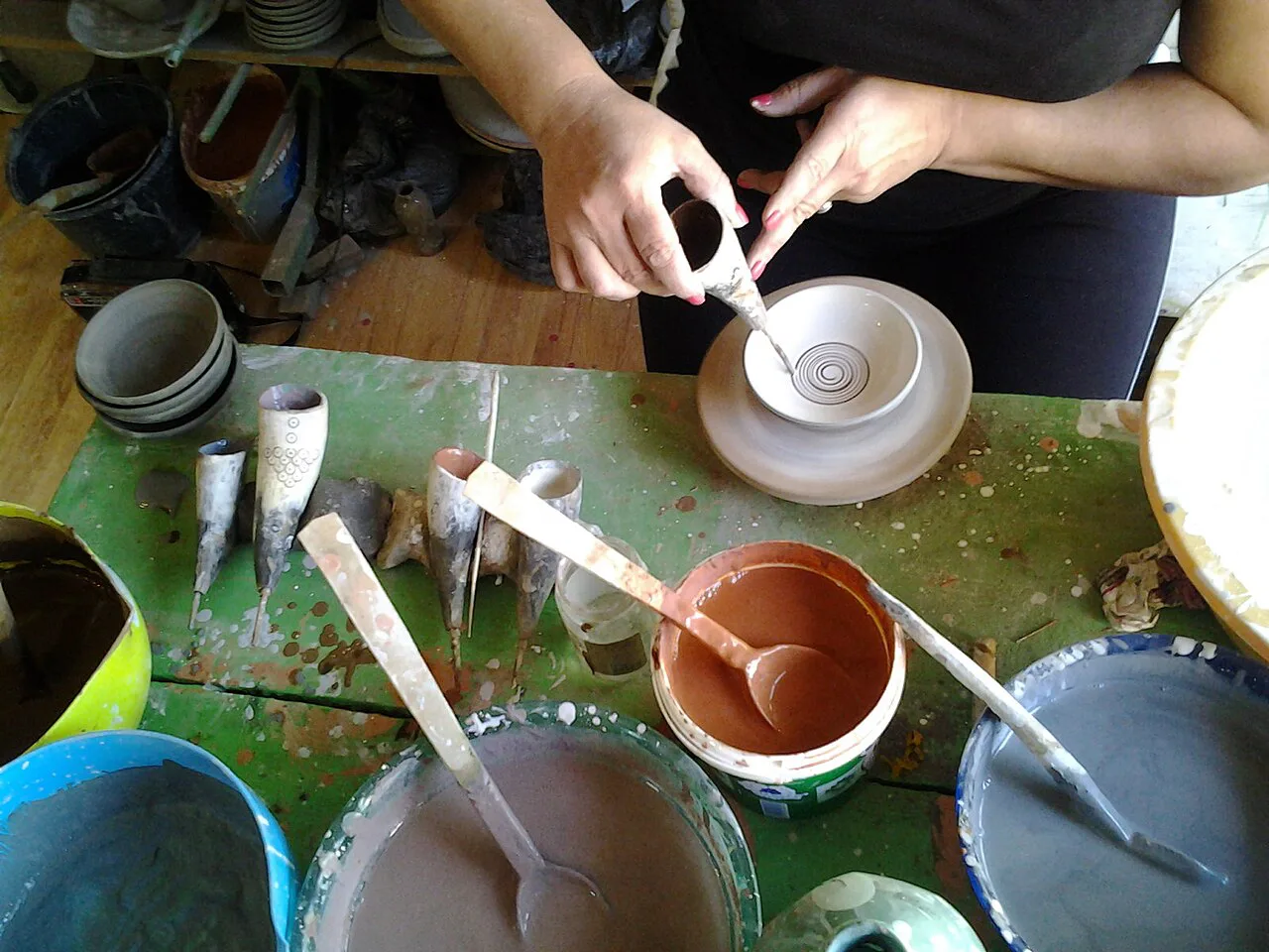 Potter painting ceramics in a Horezu workshop.