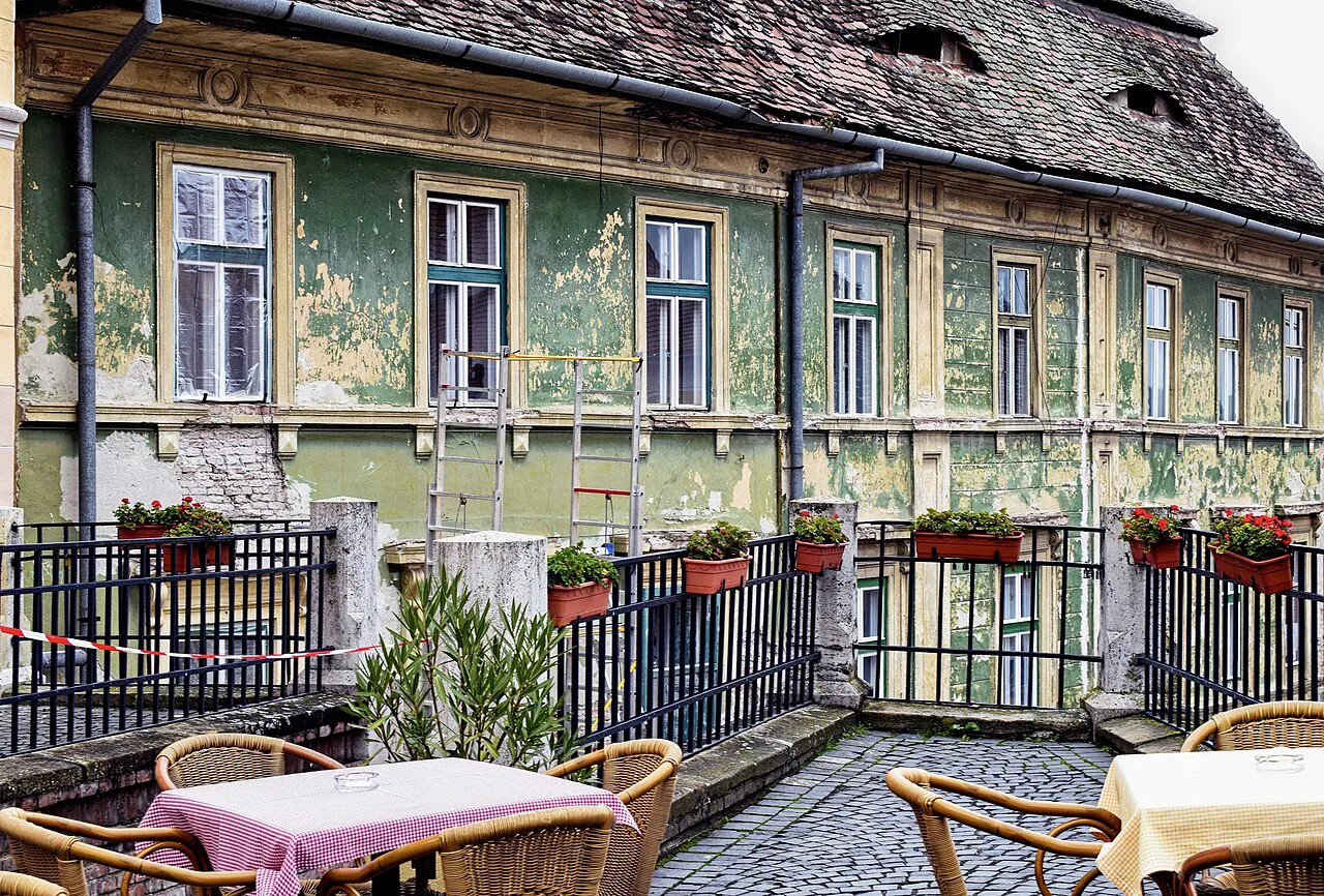 Old house with eyelid roof windows above a café terrace, Sibiu.