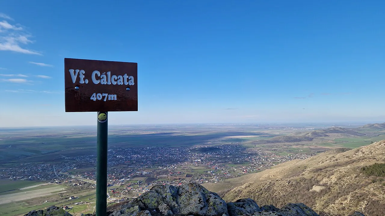 Călcata Peak sign above the Măcin Mountains, looking towards Greci.