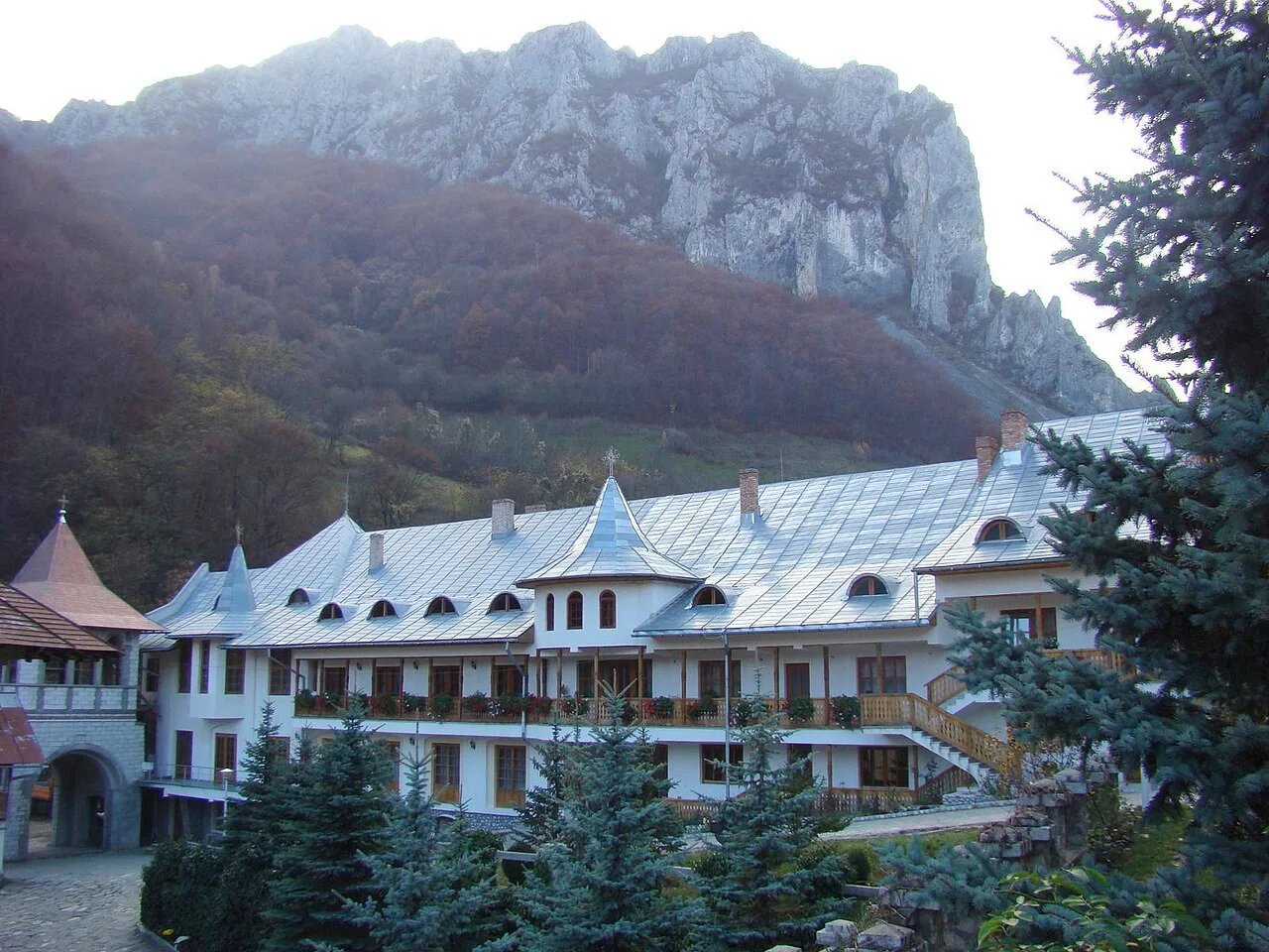 Râmeț Monastery below limestone cliffs.