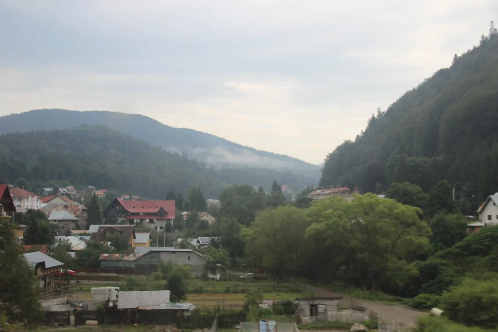 Forested Carpathian slopes above a Romanian village.
