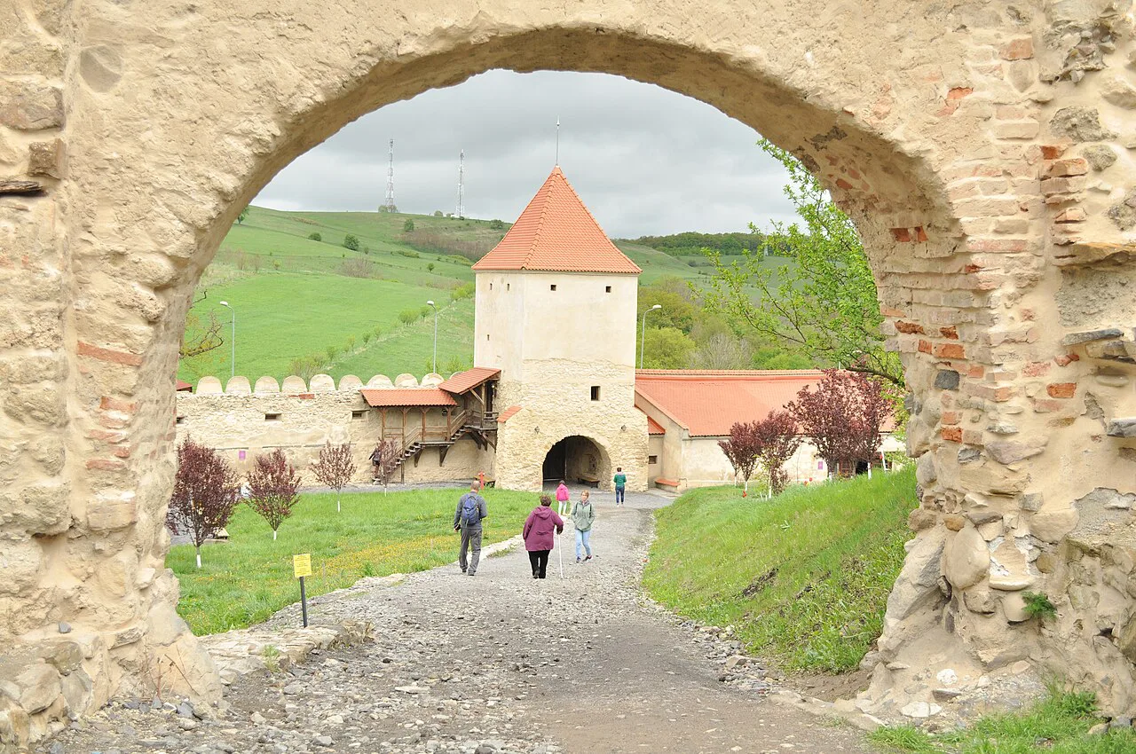 Gateway arch framing a tower of Rupea Fortress.